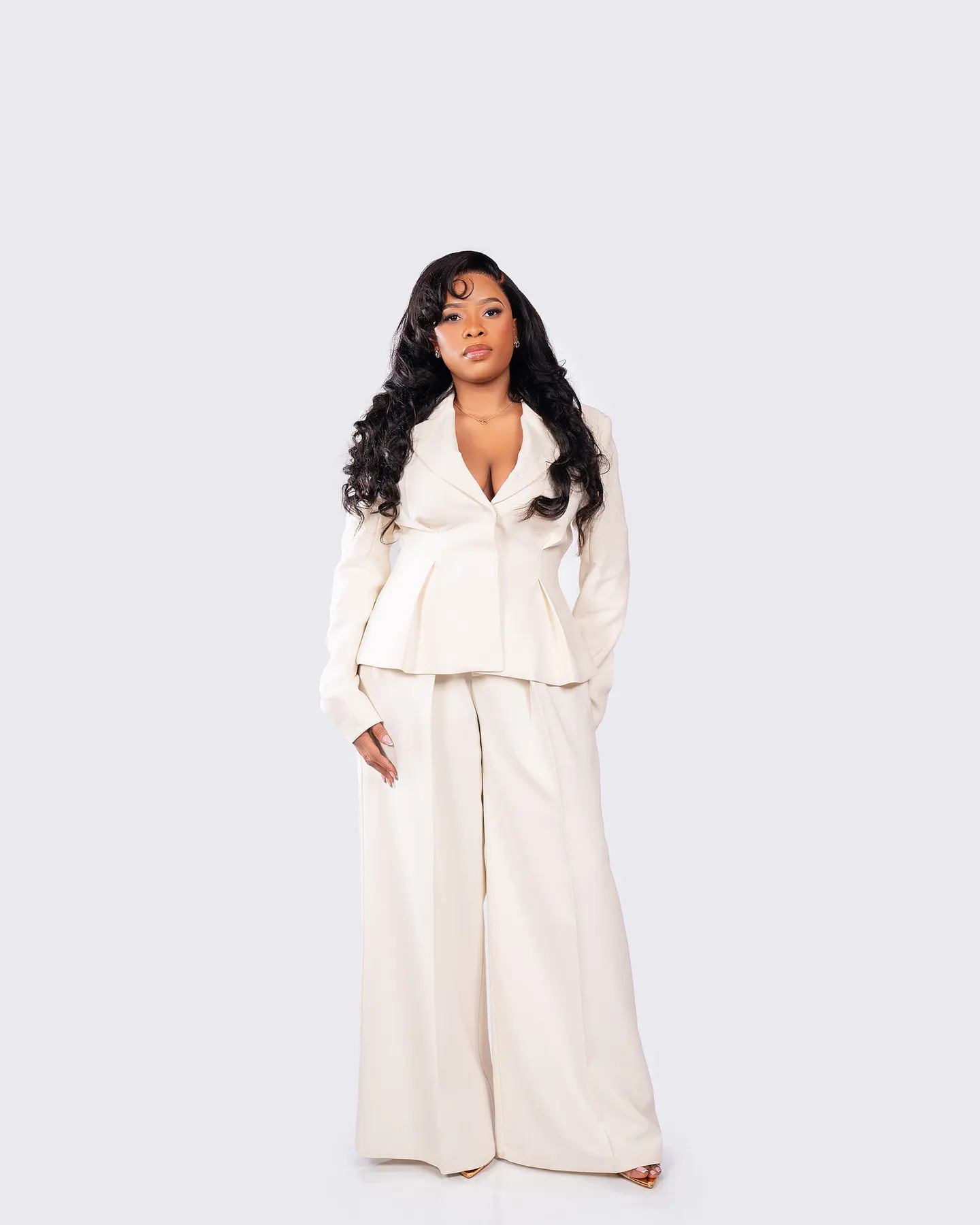 Studio portrait in a white pantsuit